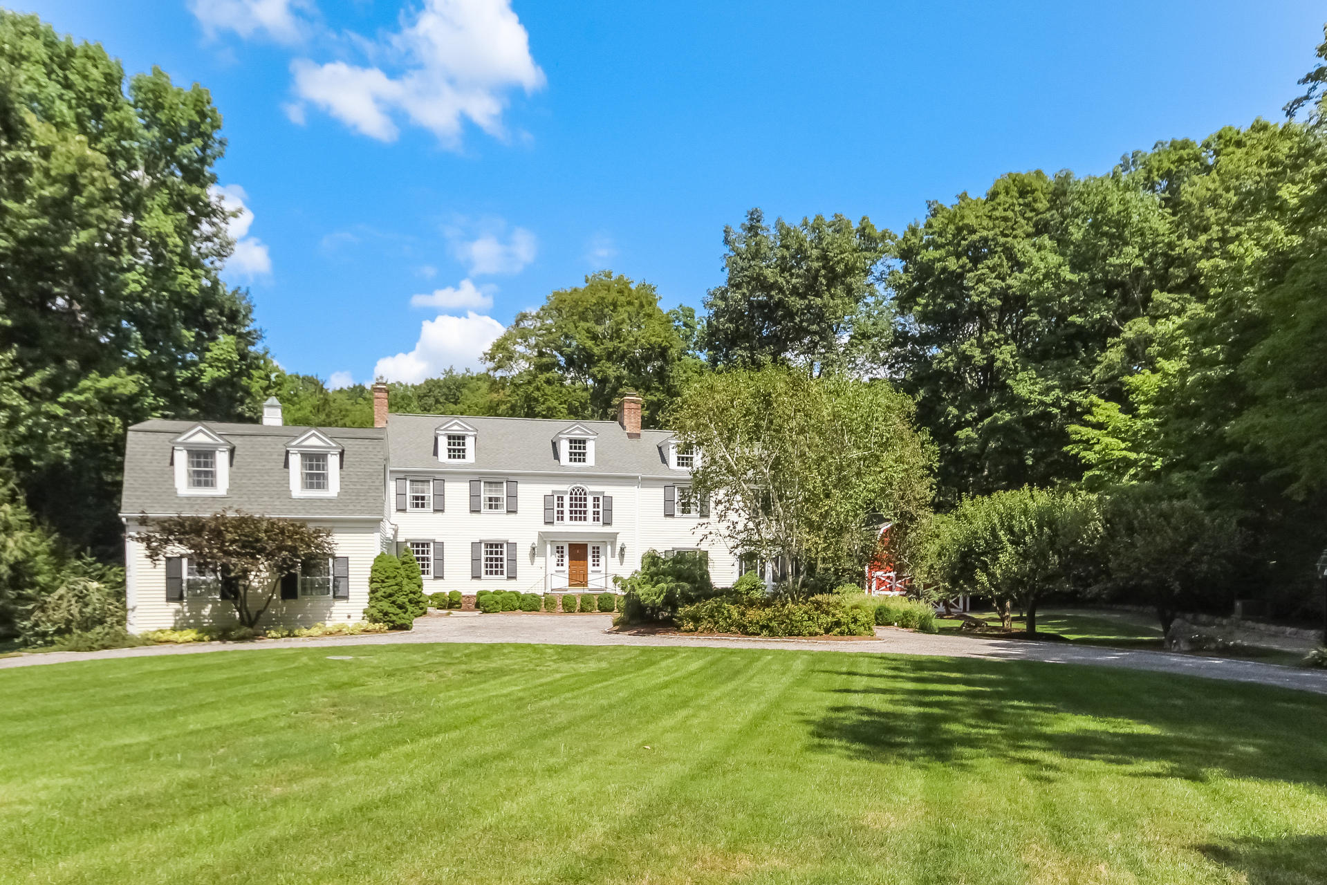 447 Valley Road New Canaan, CT 06840 - Photo 1 of 49 a front view of a house with a garden