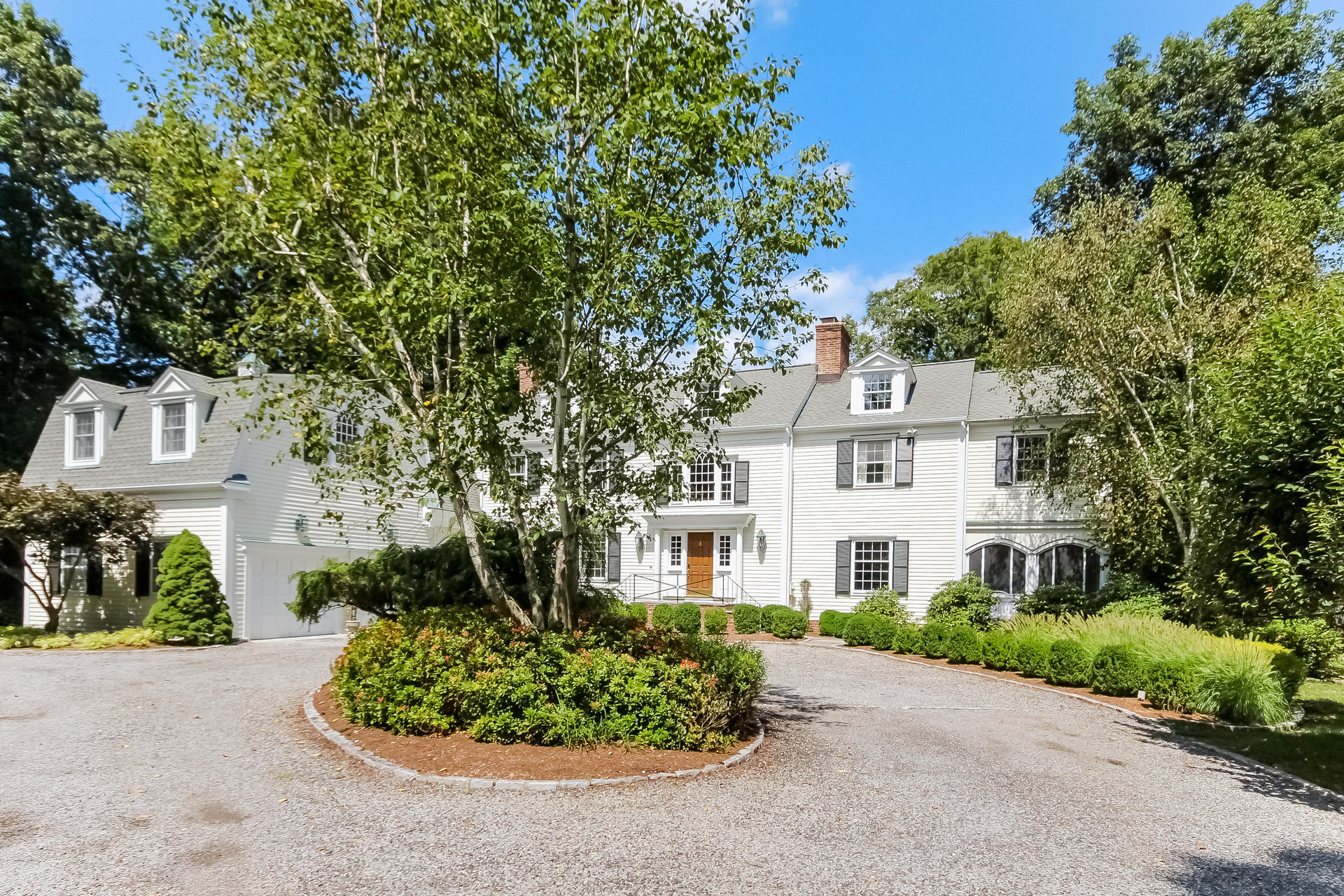 447 Valley Road New Canaan, CT 06840 - Photo 3 of 49 a front view of a house with a garden