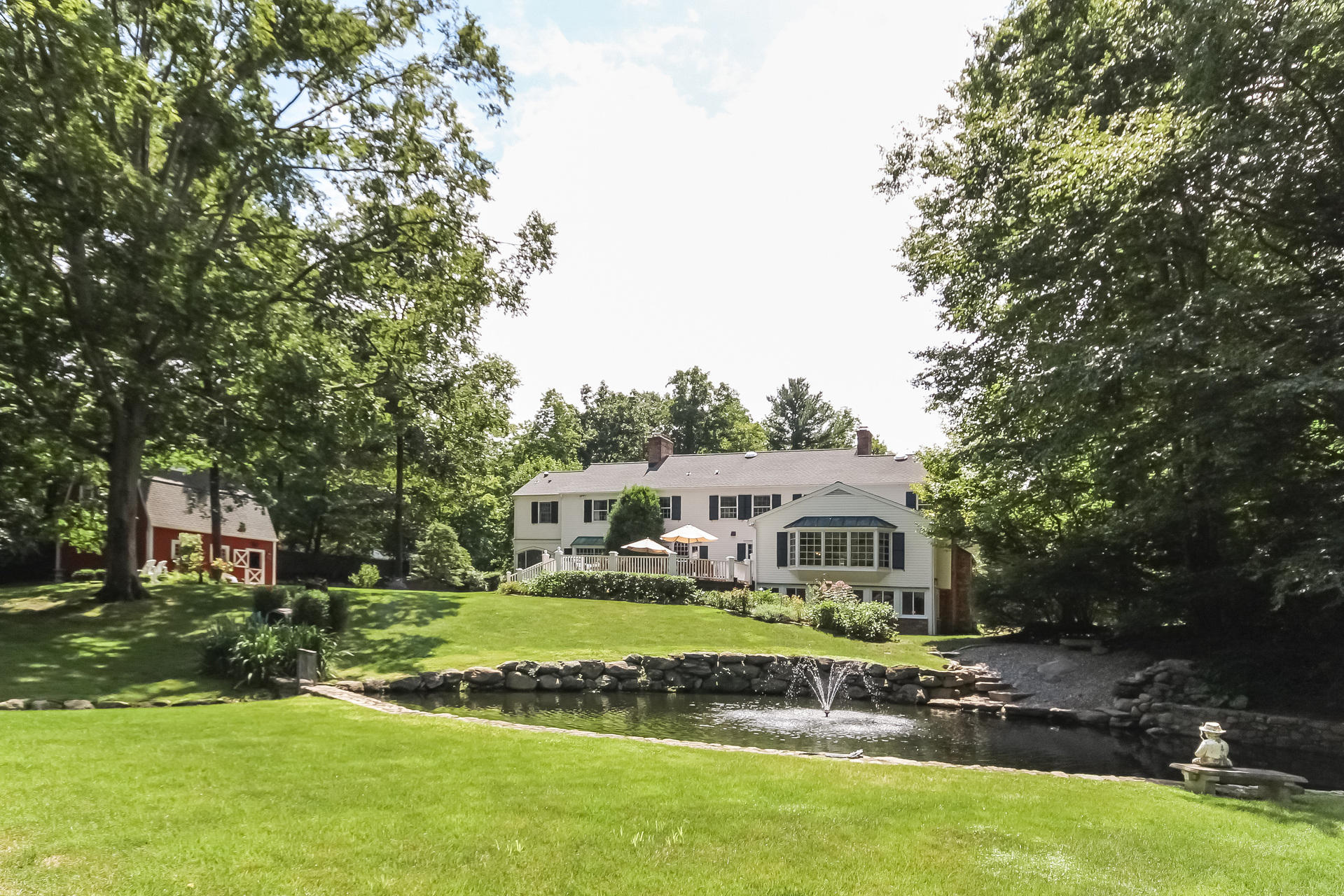 447 Valley Road New Canaan, CT 06840 - Photo 37 of 49 a front view of a house with a garden