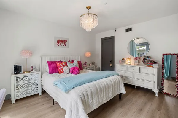 a bedroom with a bed and wooden floor