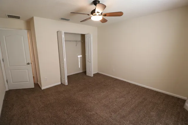 a view of empty room with ceiling fan