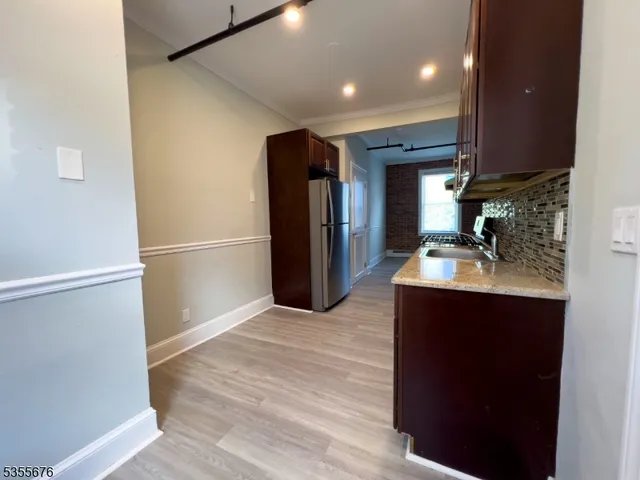a kitchen with stainless steel appliances granite countertop a refrigerator and a sink