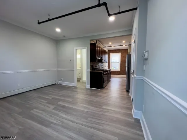 a view of a big room with wooden floor and windows