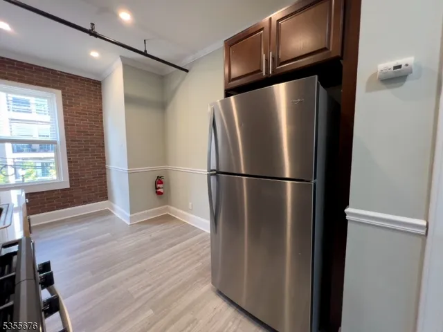 a view of a refrigerator in kitchen and wooden floor