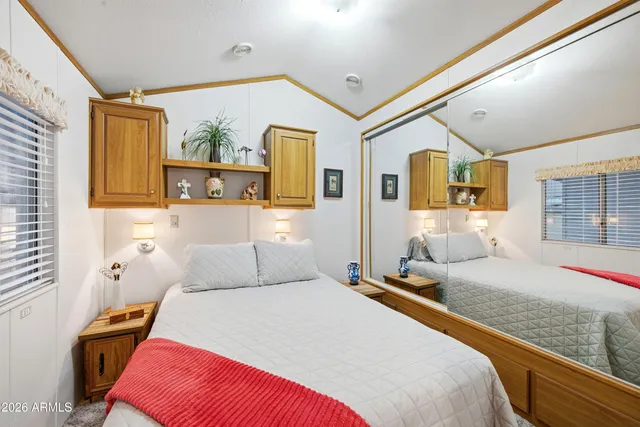 a bedroom with a bed and a large mirror