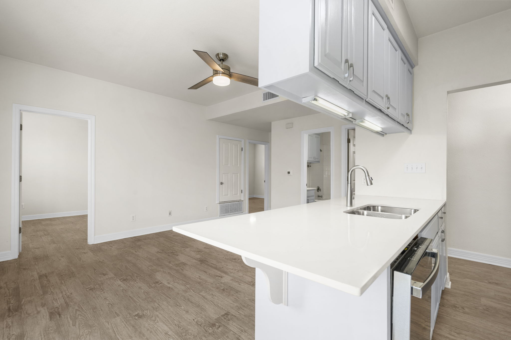 1100 West 25th Street, Unit 101 Austin, TX 78705 - Photo 23 of 39 a view of kitchen island with stainless steel appliances cabinets and wooden floor