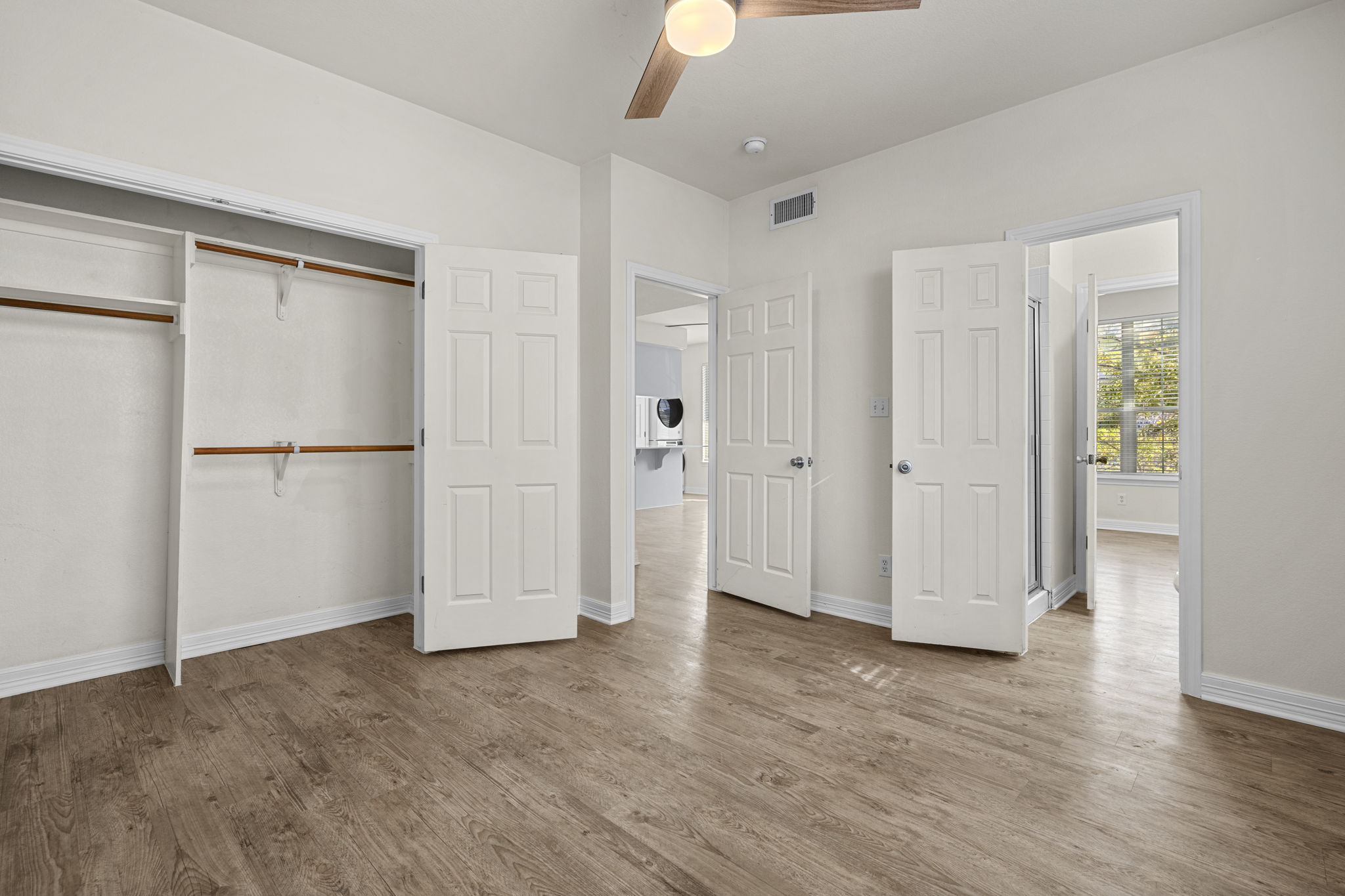 1100 West 25th Street, Unit 101 Austin, TX 78705 - Photo 35 of 39 an empty room with wooden floor and a kitchen