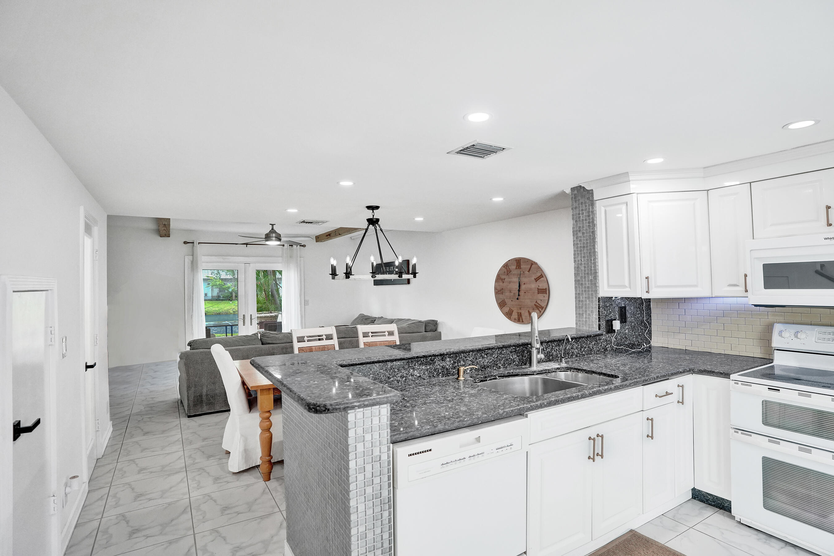 147 Southwest 3rd Street Pompano Beach, FL 33060 - Photo 4 of 29 a kitchen with granite countertop a sink and cabinets