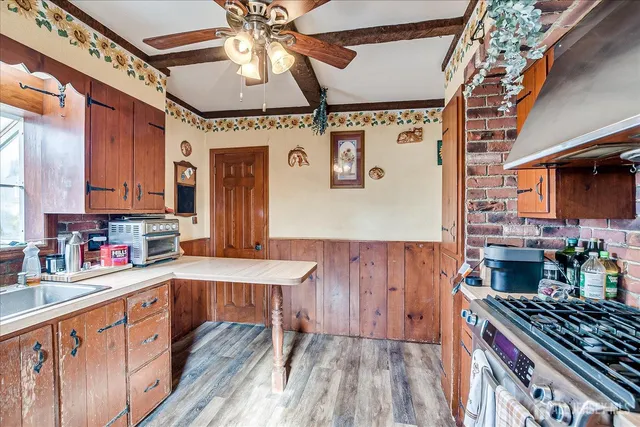 a kitchen with stainless steel appliances granite countertop a stove a sink dishwasher and cabinets with wooden floor