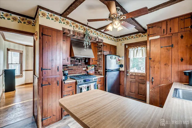 a kitchen with stainless steel appliances granite countertop a refrigerator a stove and a wooden floors