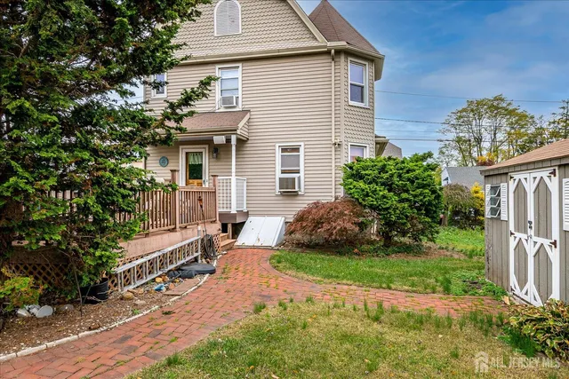a front view of a house with a yard and potted plants