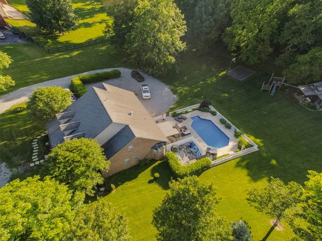 a front view of a house with a yard and trees