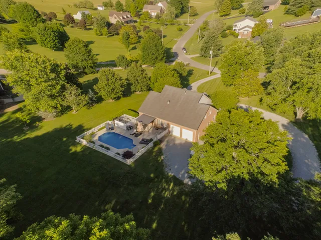 a room with stainless steel appliances kitchen island granite countertop a refrigerator and cabinets