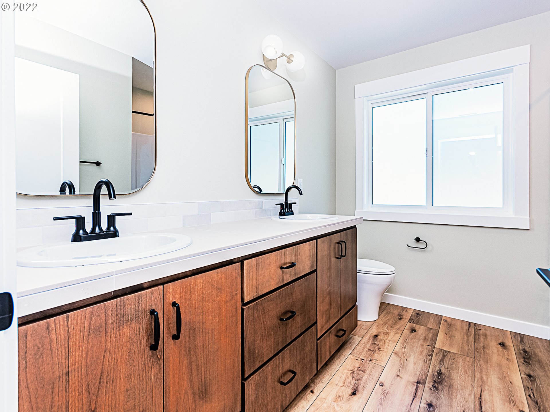2217 South Royal Court Ridgefield, WA 98642 - Photo 21 of 26 a bathroom with a double vanity sink and mirror with bathtub