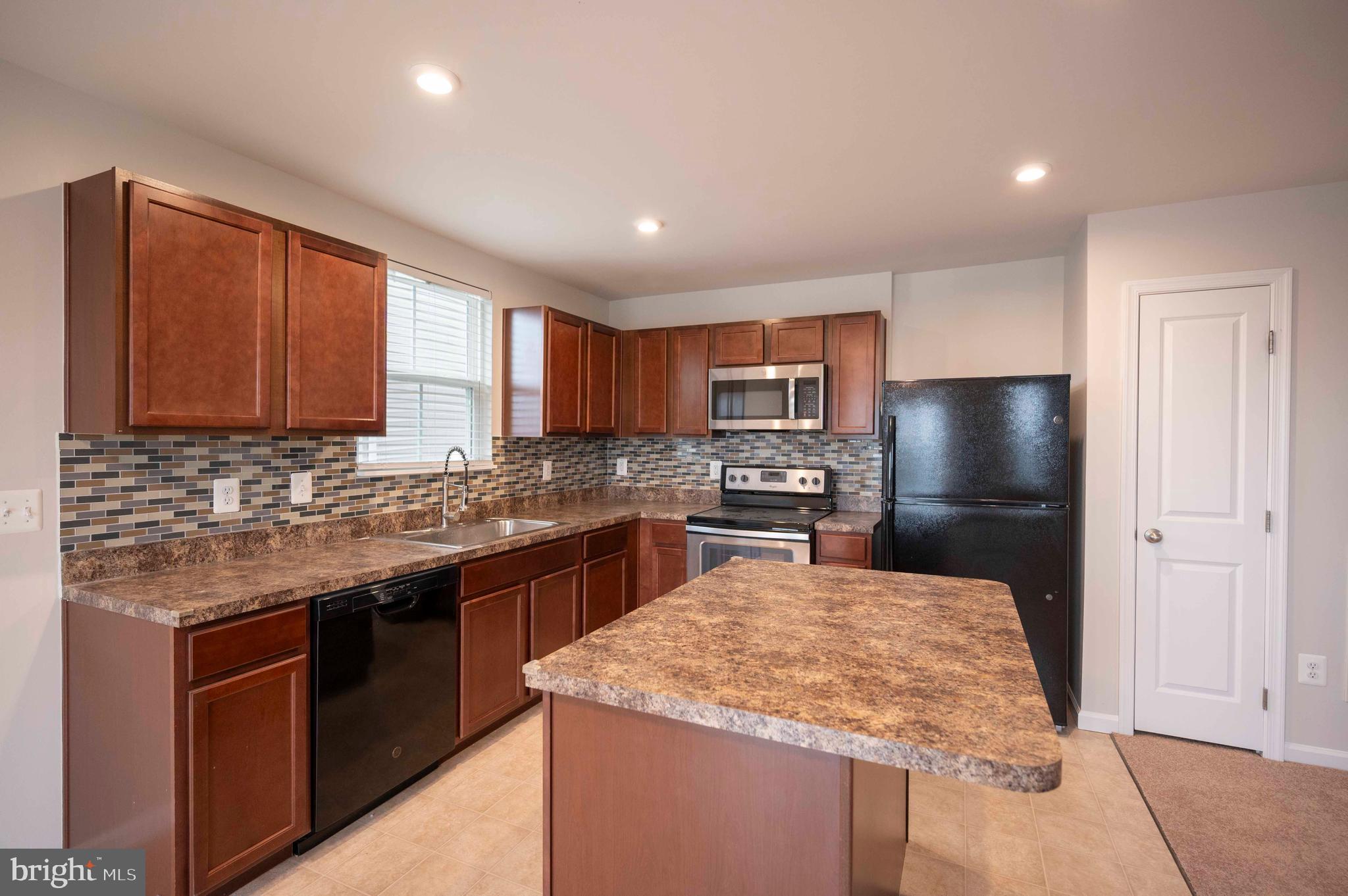 151 Cougill Road Middletown, VA 22645 - Photo 20 of 41 a kitchen with stainless steel appliances granite countertop wooden cabinets a sink dishwasher a stove and a refrigerator with wooden floor