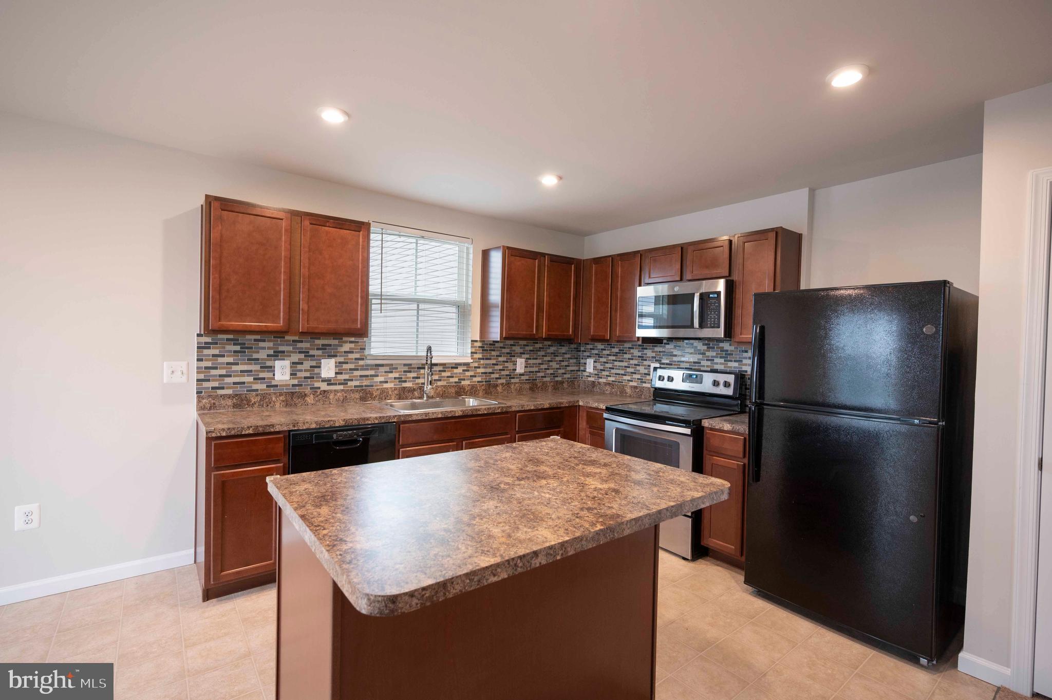 151 Cougill Road Middletown, VA 22645 - Photo 21 of 41 a kitchen with a refrigerator a microwave a sink and a counter in it