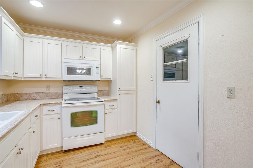856 Broadway Avenue Euless, TX 76040 - Photo 14 of 35 a kitchen with white cabinets and white appliances