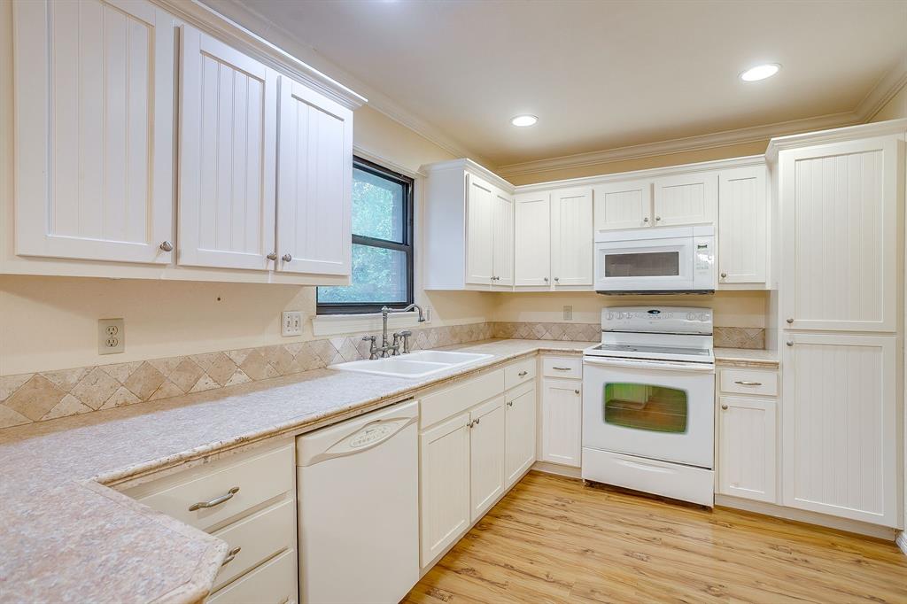 856 Broadway Avenue Euless, TX 76040 - Photo 16 of 35 a kitchen with cabinets appliances a sink and a counter top space