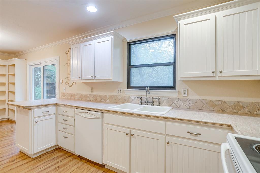 856 Broadway Avenue Euless, TX 76040 - Photo 17 of 35 a kitchen with granite countertop white cabinets and sink
