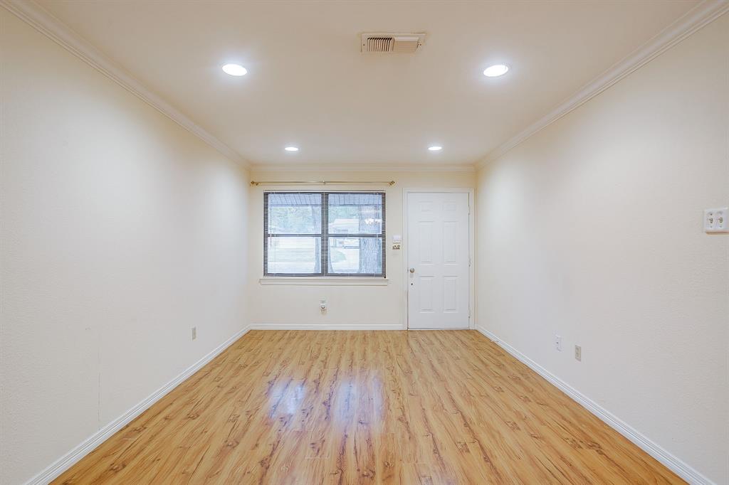 856 Broadway Avenue Euless, TX 76040 - Photo 4 of 35 an empty room with wooden floor and windows
