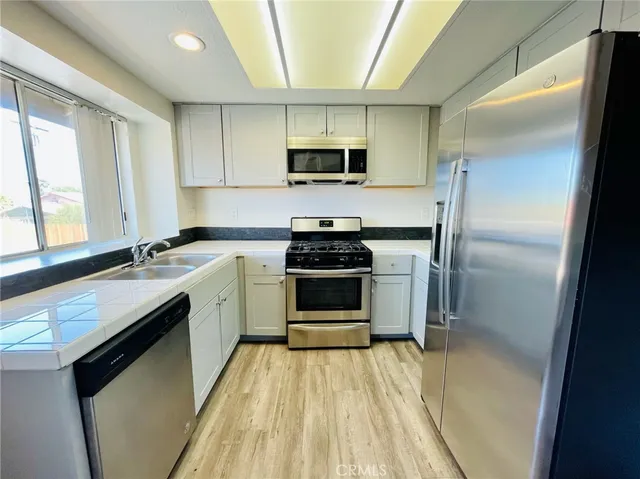 a kitchen with a sink appliances and cabinets