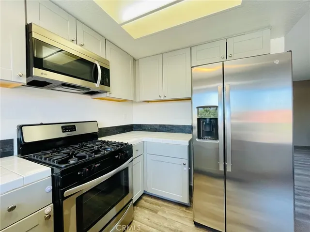 a kitchen with stainless steel appliances granite countertop a stove and a refrigerator