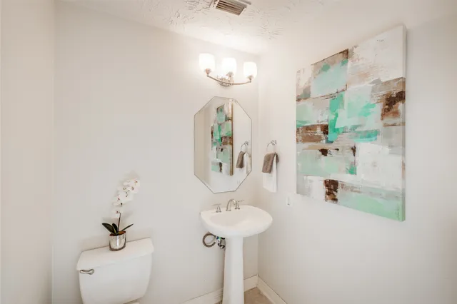 an empty room with a chandelier fan and windows