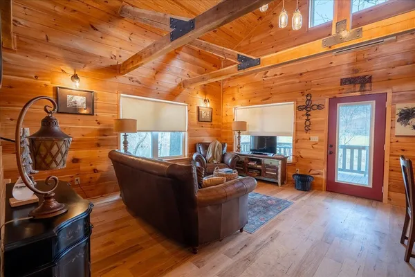 a living room with couches and a flat screen tv with wooden floor