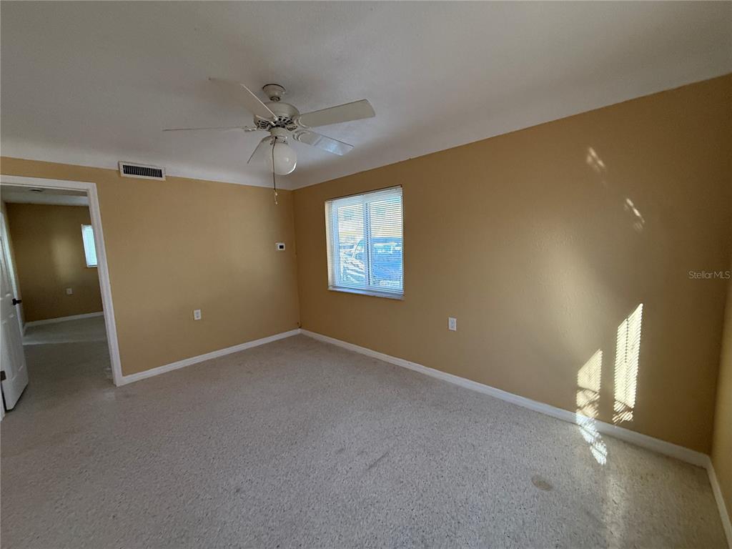 17688 Gulf Boulevard, Unit 104 Redington Shores, FL 33708 - Photo 9 of 15 an empty room with windows and fan