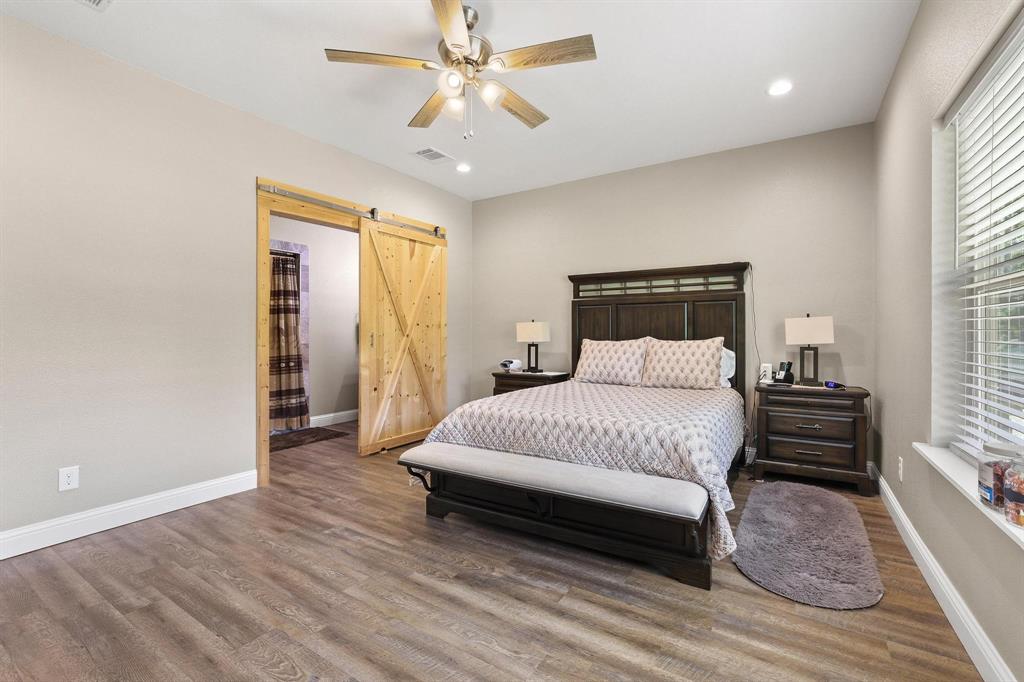 2658 Oak Ridge Road Denison, TX 75021 - Photo 18 of 37 a spacious bedroom with a bed and wooden floor
