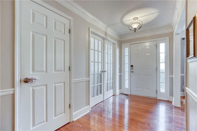 a kitchen with stainless steel appliances granite countertop a stove top oven a sink a refrigerator with a dining table and chairs