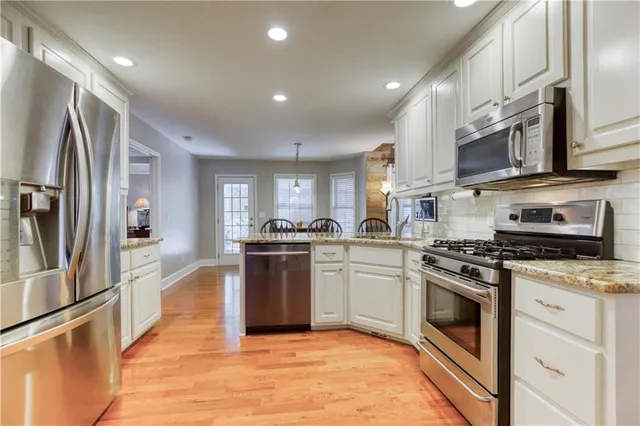 a bathroom with a granite countertop sink a toilet and a window
