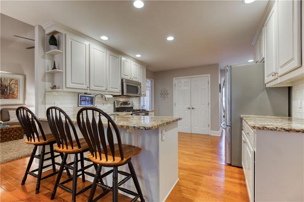 2521 Culpepper Trail Southeast Bethlehem, GA 30620 - Photo 34 of 83 a kitchen with stainless steel appliances granite countertop a stove top oven a sink a refrigerator with a dining table and chairs