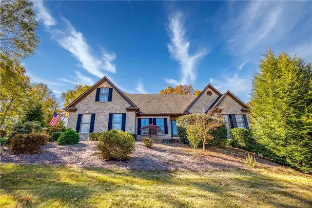 a view of a dining room and livingroom with furniture wooden floor a chandelier