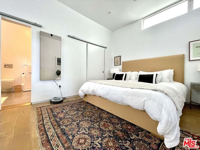 a bedroom with a bed and wooden floor