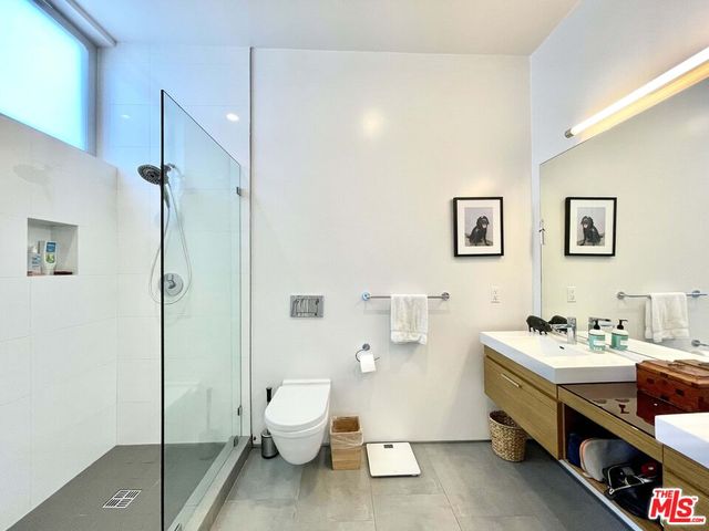 a spacious bathroom with a double vanity sink toilet and shower