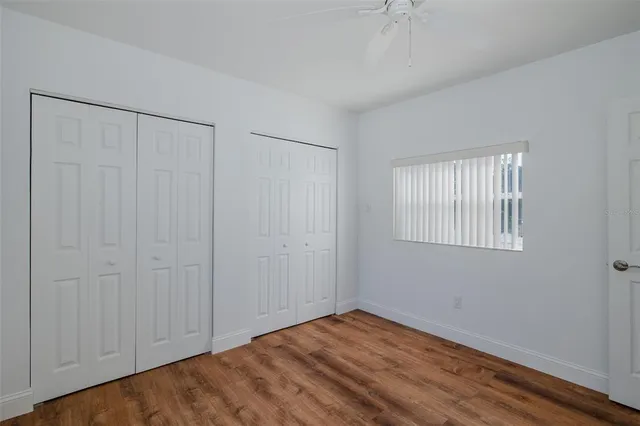 a view of kitchen with stainless steel appliances kitchen island wooden floors and living room view