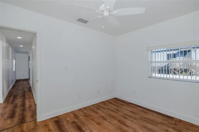 wooden floor in an empty room with a window
