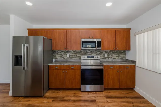 a kitchen with stainless steel appliances granite countertop a sink stove and refrigerator