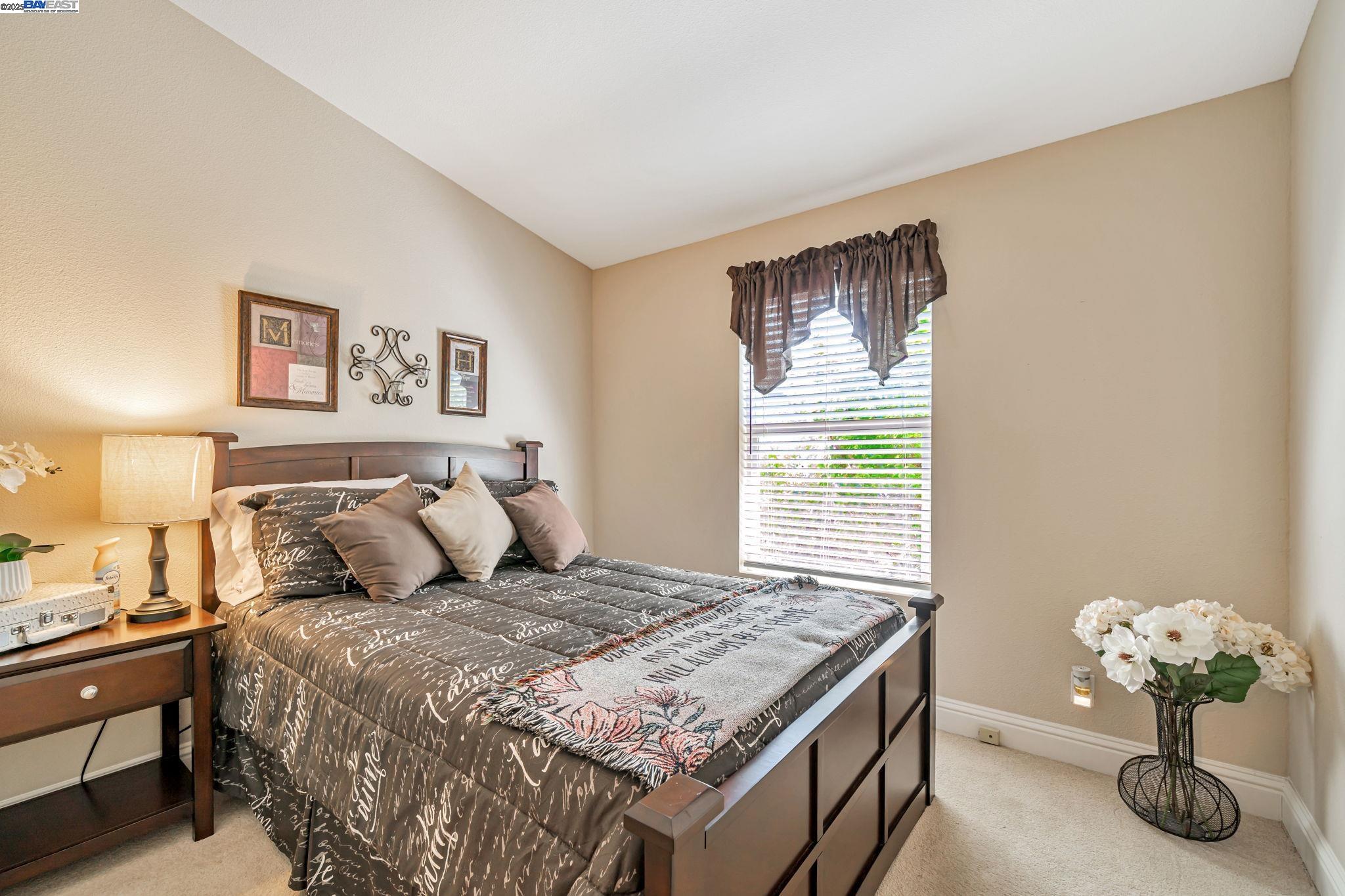 3263 Vineyard, Unit 68 Pleasanton, CA 94566 - Photo 21 of 41 a bedroom with a bed and a chandelier