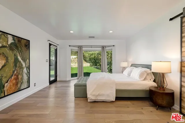 a bedroom with a large bed and a large window