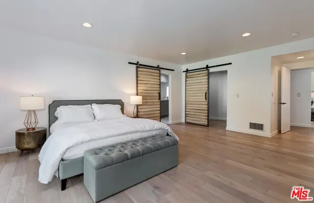 a spacious bedroom with a bed and a walk in closet