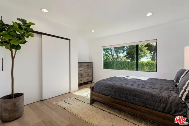 a bedroom with a bed table and a window