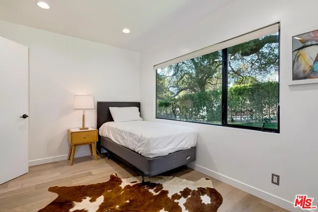 a bed sitting in a bedroom next to a window