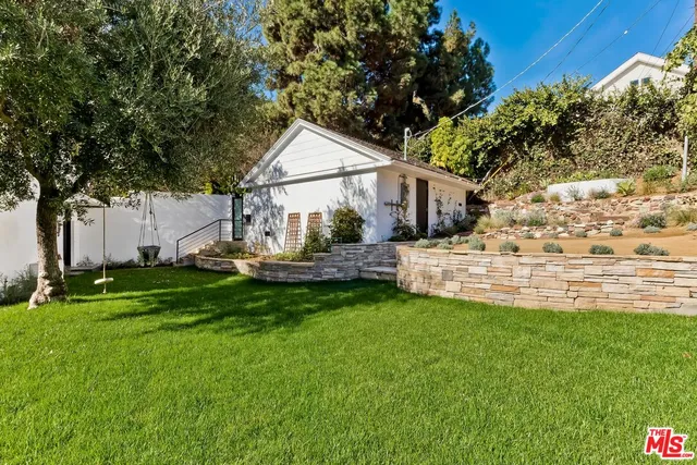 a view of a house with backyard and sitting area