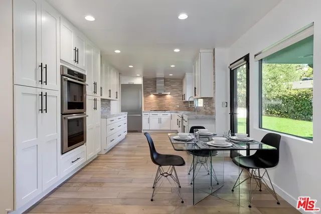 a kitchen with a table chairs refrigerator and cabinets