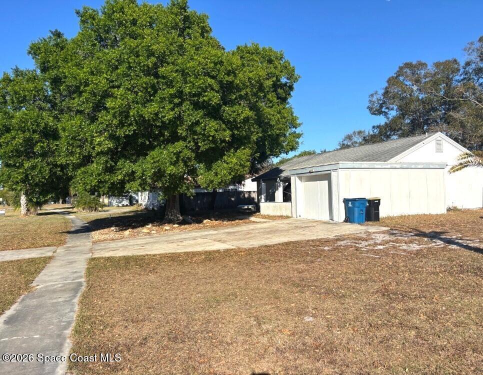 1614 Riviera Drive Northeast Palm Bay, FL 32905 - Photo 2 of 3 a view of a house with a yard and garage