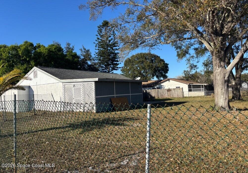1614 Riviera Drive Northeast Palm Bay, FL 32905 - Photo 3 of 3 a view of a white house with a yard and large tree