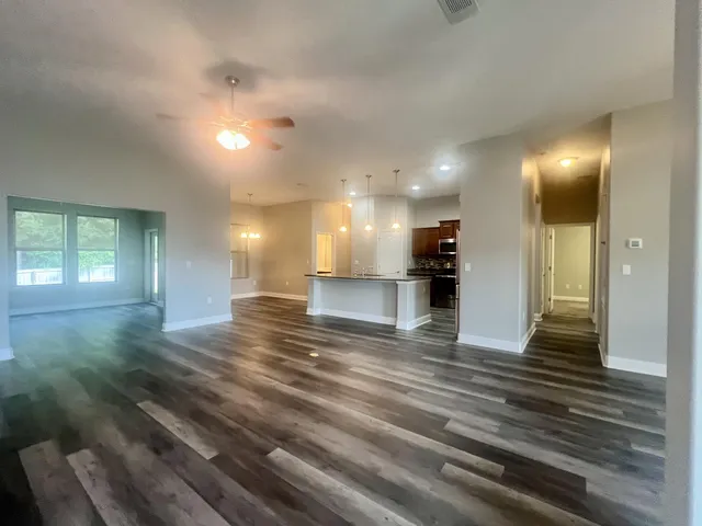 a view of an empty room and kitchen view