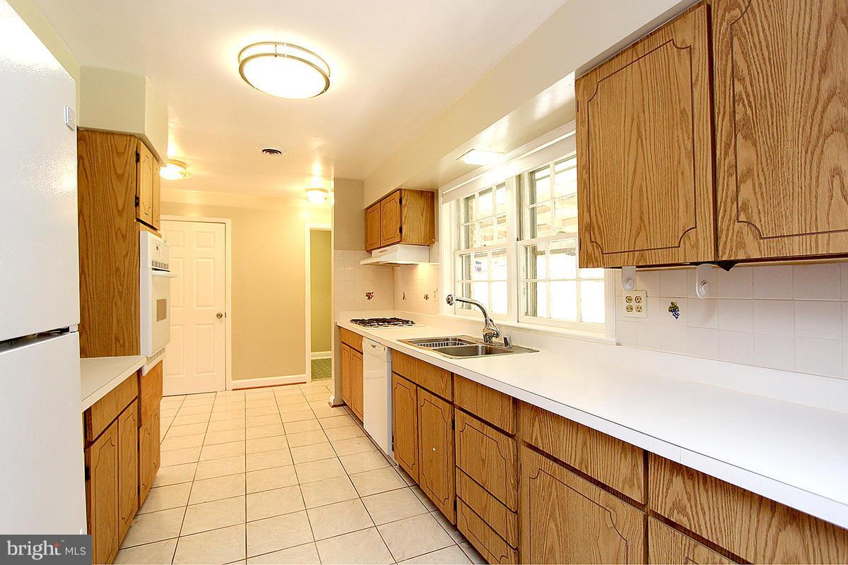 17216 Donora Road Silver Spring, MD 20905 - Photo 12 of 28 a kitchen with a sink a stove and cabinets